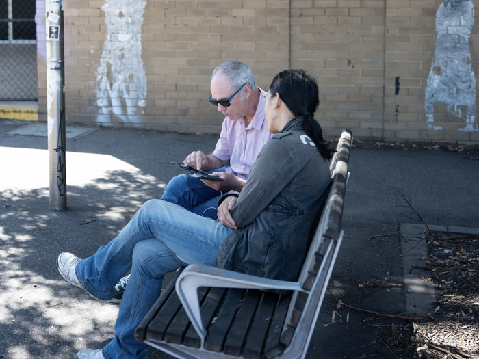 Burnet researcher sitting on a bench with a SuperMIX participant.