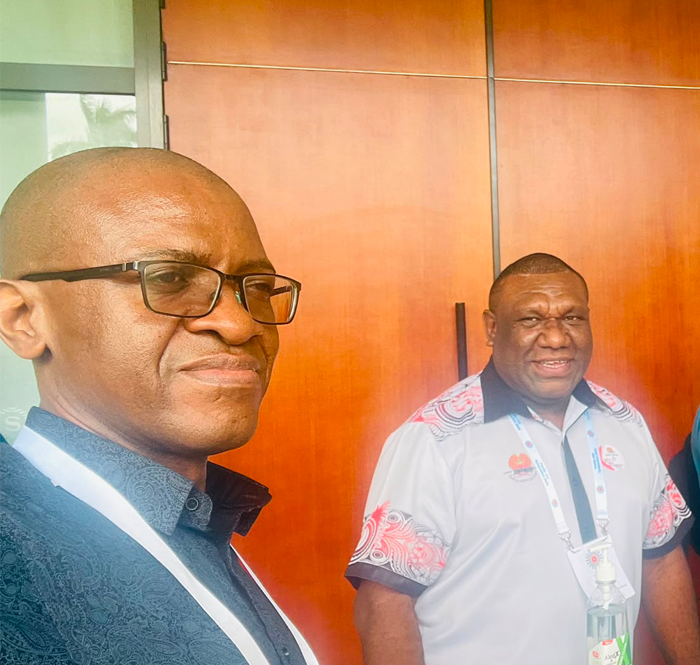 Two men photographed standing in front of a door. They are Dr Tafireyi Marukutira and Dr Kennan Witari