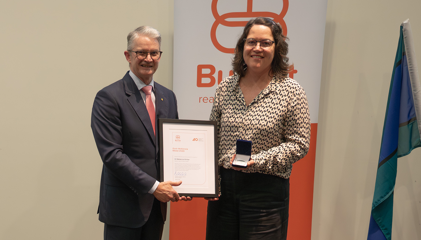 Dr Rebecca Winter receives the 2026 Gust-McKenzie Medal at Burnet’s annual general meeting, holding the medal alongside her award certificate.