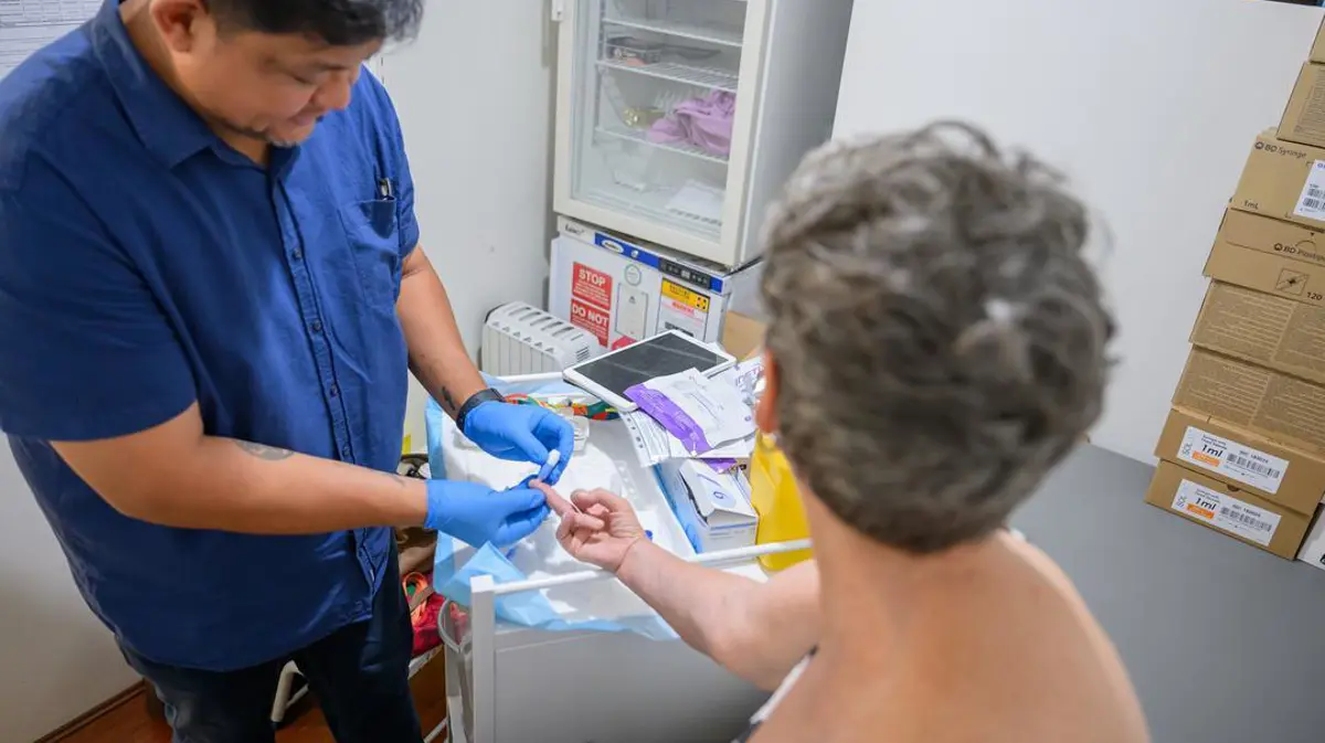 A clinical research nurse collecting a finger prick sample.