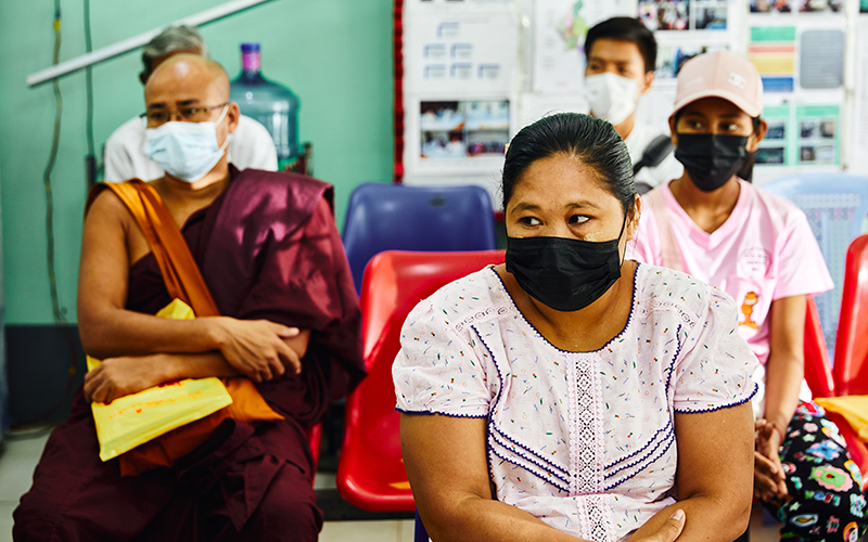 Image: Clients in masks attend a health clinic in Yangon, Myanmar