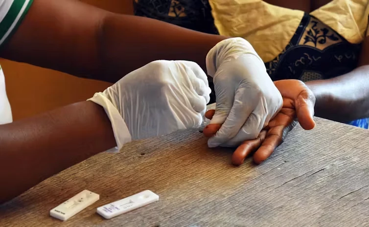 Finger prick blood test being administered.