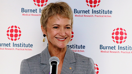 Professor Caroline Homer standing in front of Burnet banner