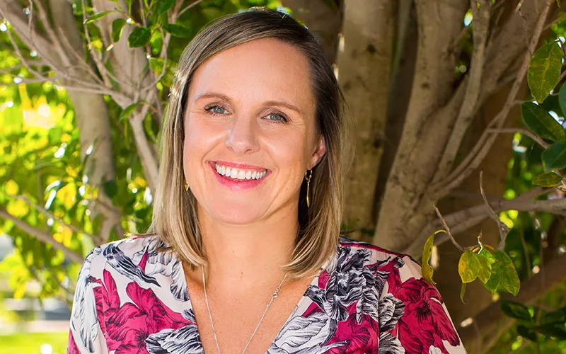 Belinda Collins photographed in front of a tree