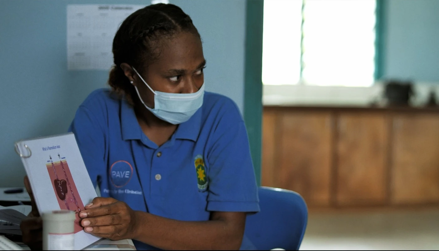 A health worker from Papua New Guinea Institute of Medical Research points to an illustration of primaquine.