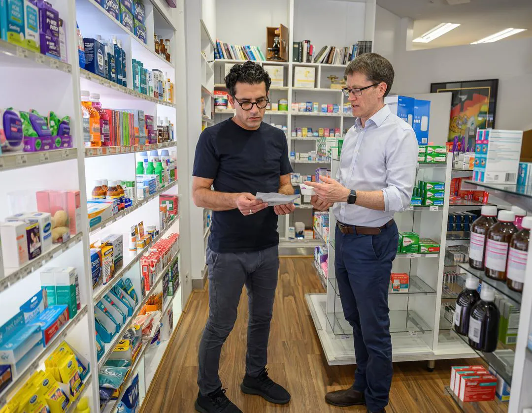 A pharmacist providing advice in a pharmacy.