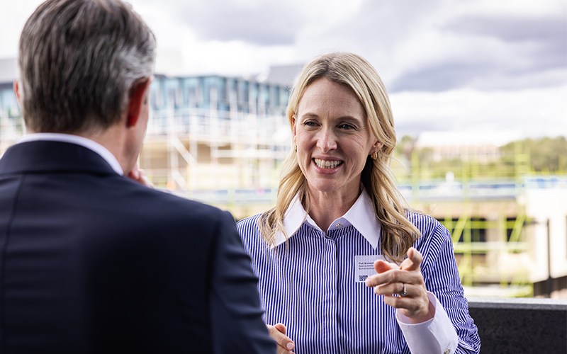 Portrait of Bronwyn King speaking to an unidentified man