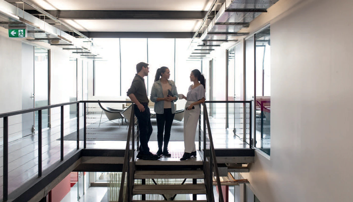 Group of people meeting and chatting in an airy office.