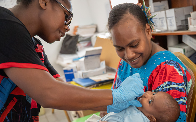Healthcare worker with mother and baby in Vanuatu.