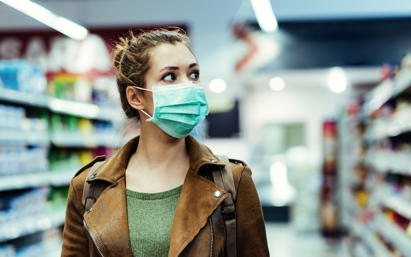 Woman in grocery store wearing surgical mask